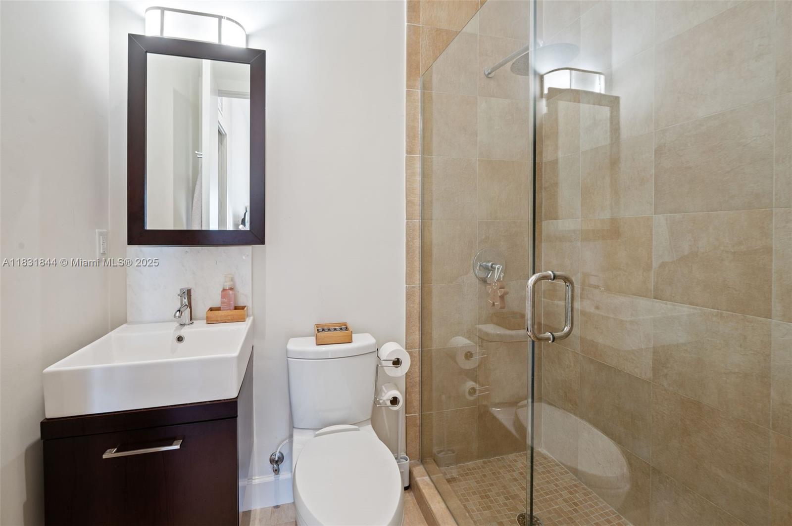 7560 Southwest 56th Court Miami, FL 33143 - Photo 36 of 60 a bathroom with a toilet sink vanity and mirror