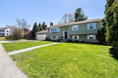 a front view of a house with a yard and trees