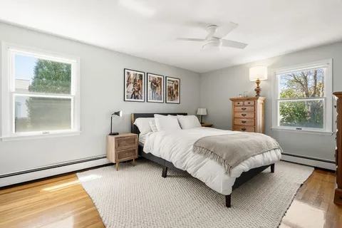 a bedroom with a bed painting and a window