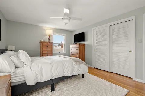 a bedroom with a bed and a flat tv screen on dresser