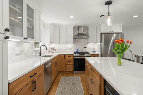 a kitchen with stainless steel appliances granite countertop a sink a stove and a refrigerator