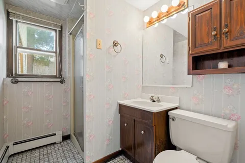 a bathroom with a sink a toilet and shower