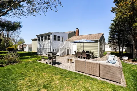 a view of a house with backyard sitting area and garden