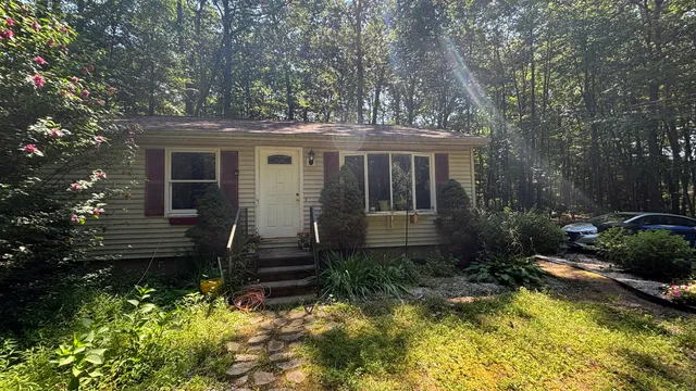 a view of a house with backyard and sitting area