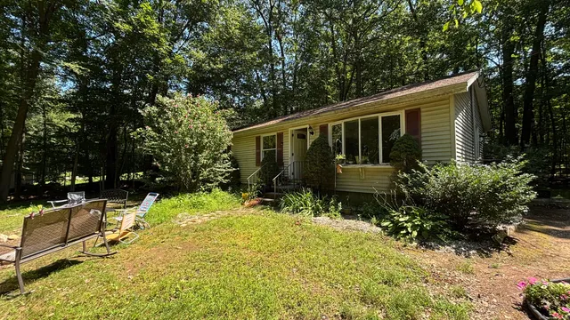 a front view of a house with a yard table and chairs