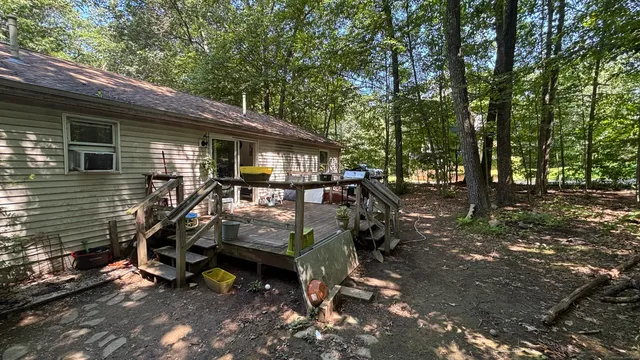 a view of a house with backyard and chairs