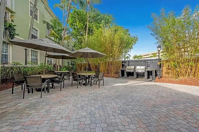 a view of a patio with table and chairs under an umbrella