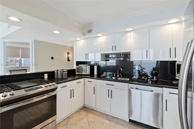 a kitchen with white cabinets and appliances