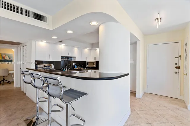 a kitchen with stainless steel appliances granite countertop a sink and a refrigerator