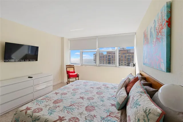 a bed room with a bed a television and a window