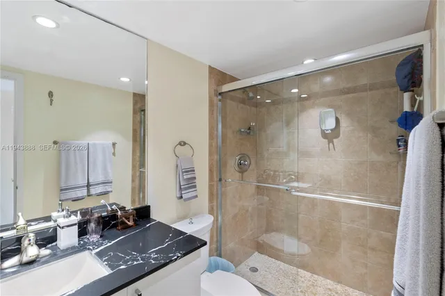 a bathroom with a granite countertop sink a toilet and shower