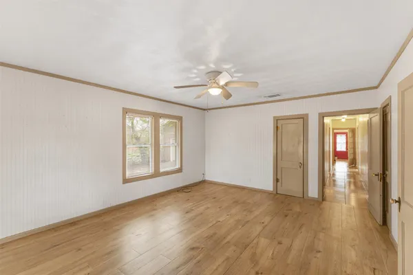 a view of an empty room with glass door and a window