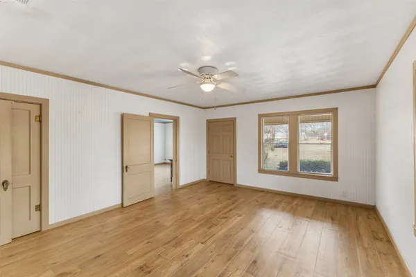 an empty room with wooden floor and windows