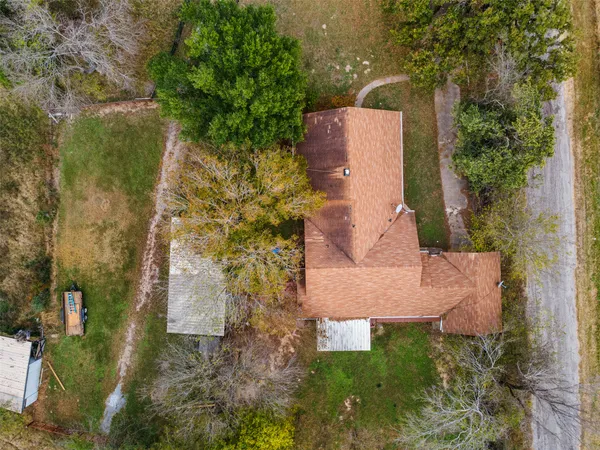 an aerial view of a house with a yard and trees