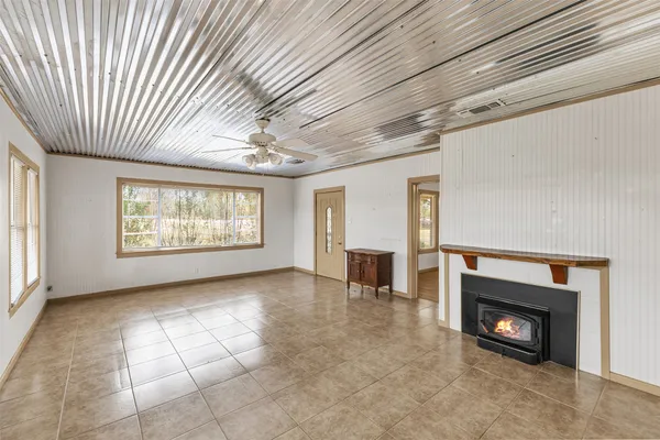a view of an empty room with a fireplace and a window