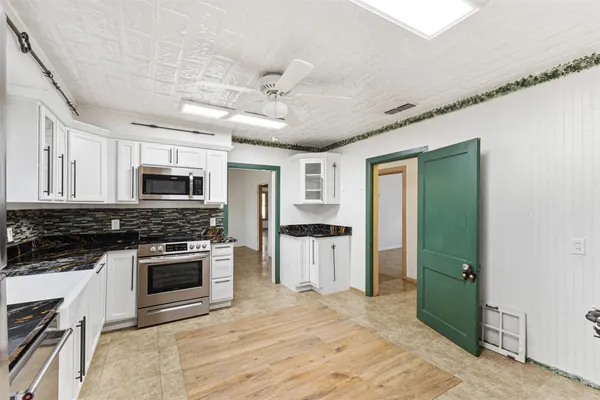 a kitchen with stainless steel appliances granite countertop a stove sink and microwave