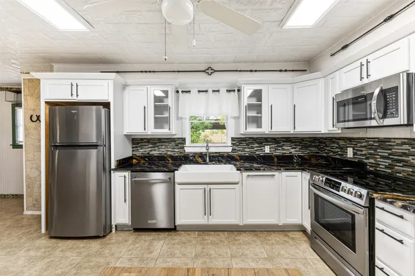 a kitchen with stainless steel appliances granite countertop a stove a refrigerator and a microwave
