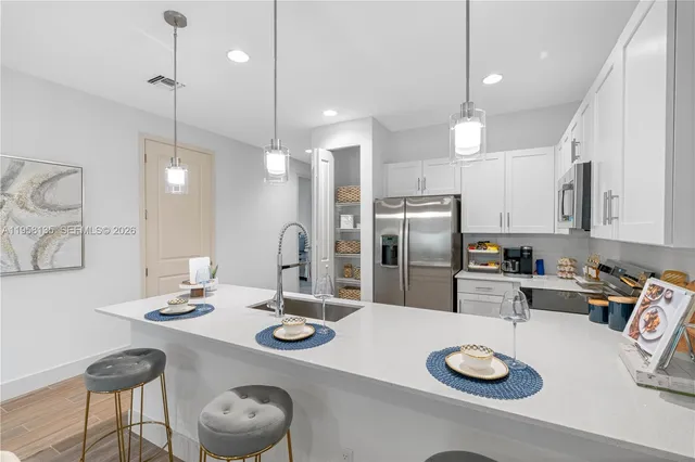a kitchen with refrigerator and wooden floor