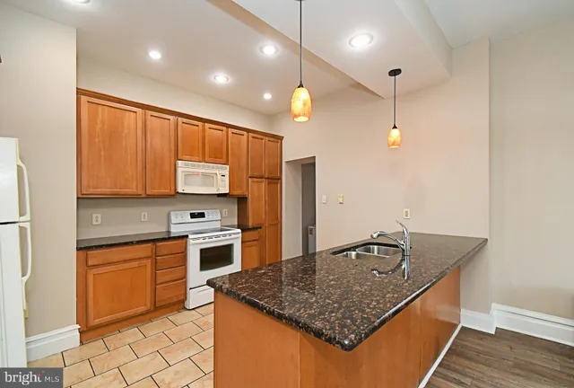 a kitchen with stainless steel appliances granite countertop a sink a stove and refrigerator