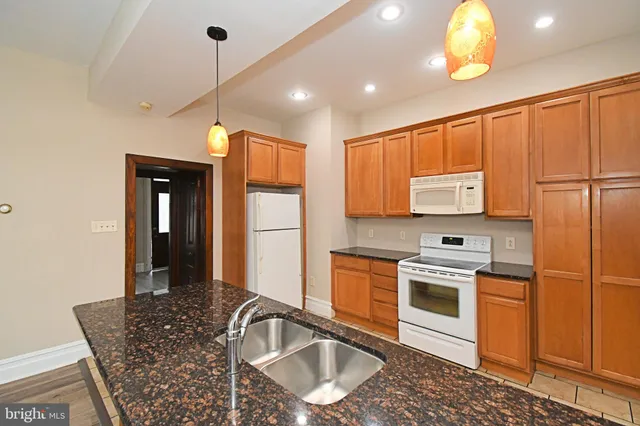 a kitchen with granite countertop cabinets a sink a window and stainless steel appliances