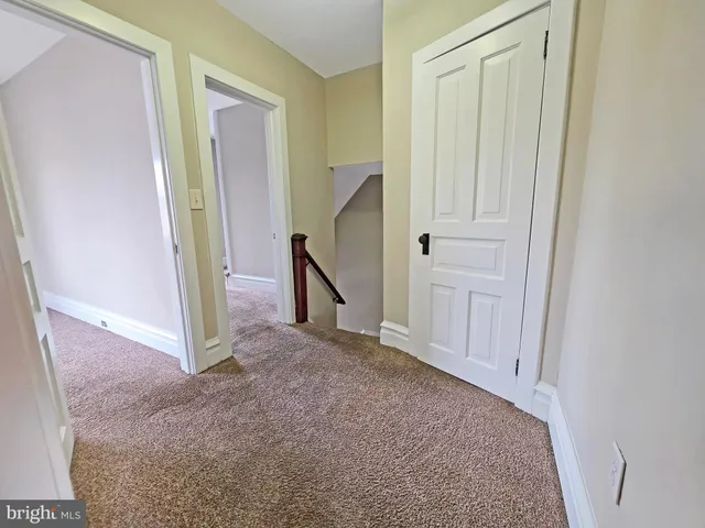an empty room with windows and chandelier fan