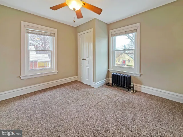 a view of staircase with white walls and white door