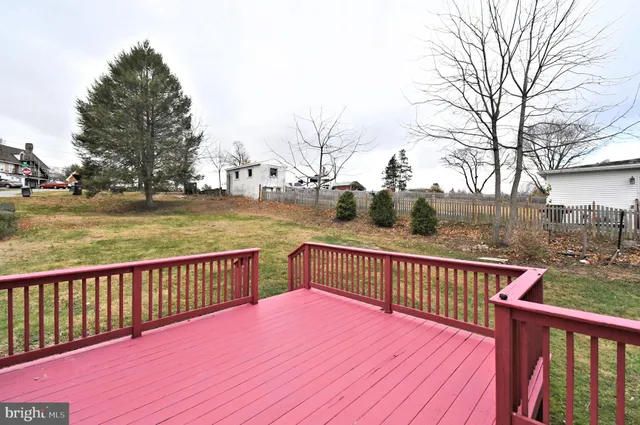 a view of a house with a big yard plants and large trees