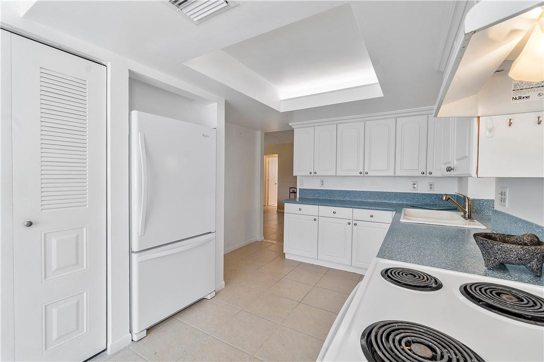 6419 Hitchin Post Way Delray Beach, FL 33484 - Photo 13 of 33 a kitchen with a refrigerator and white cabinets