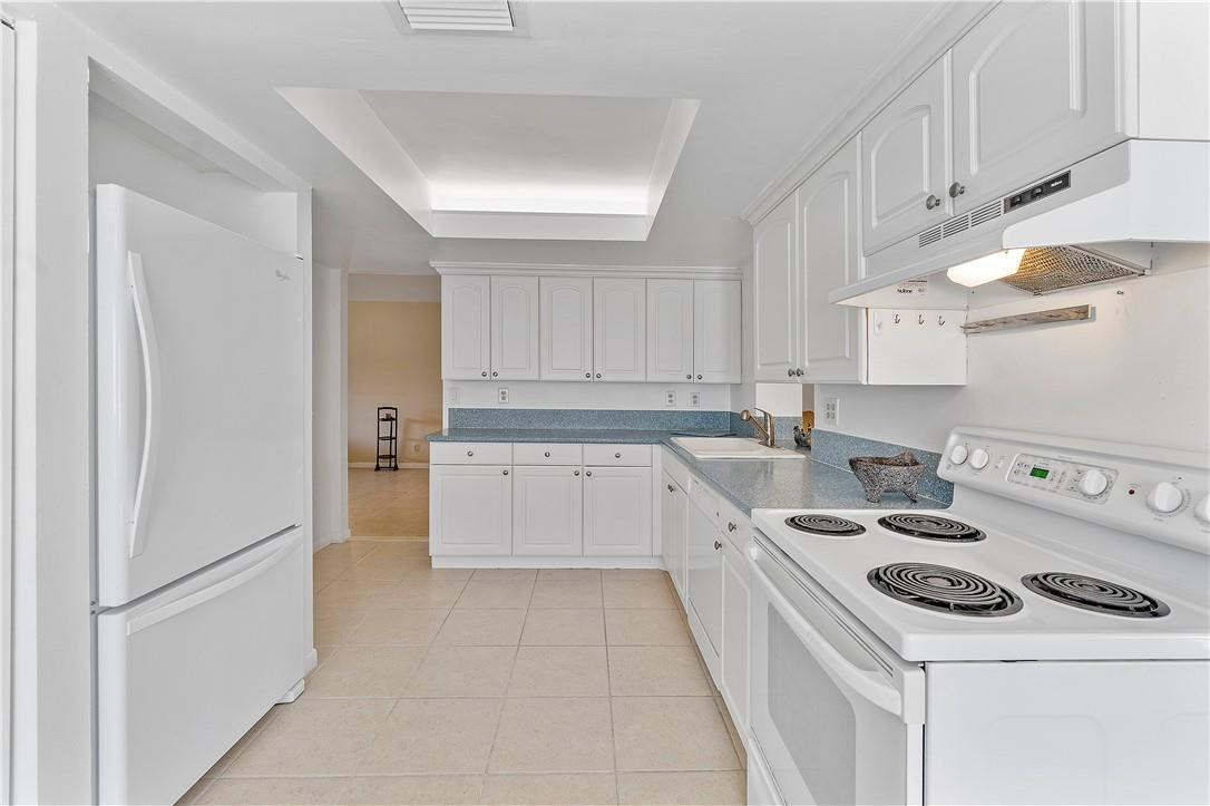 6419 Hitchin Post Way Delray Beach, FL 33484 - Photo 14 of 33 a kitchen with a white stove top oven and white cabinets
