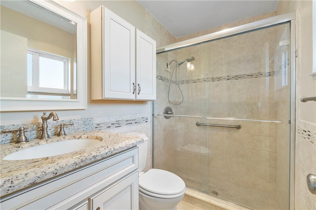 6419 Hitchin Post Way Delray Beach, FL 33484 - Photo 23 of 33 a bathroom with a granite countertop sink a mirror and a shower