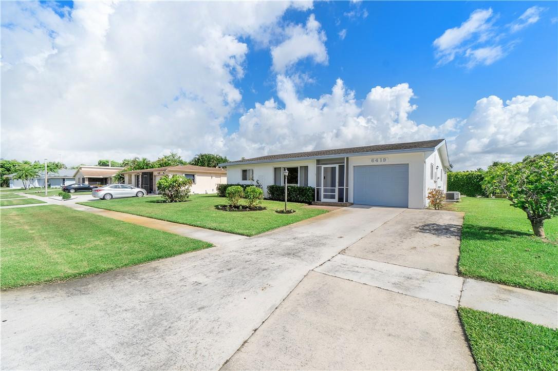 6419 Hitchin Post Way Delray Beach, FL 33484 - Photo 26 of 33 a view of house with yard street and trees in the background