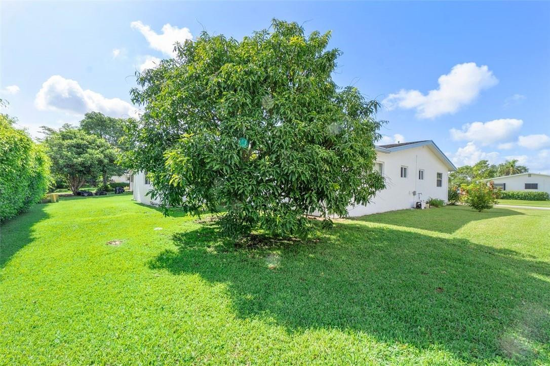 6419 Hitchin Post Way Delray Beach, FL 33484 - Photo 29 of 33 a view of white house with a big yard and large trees