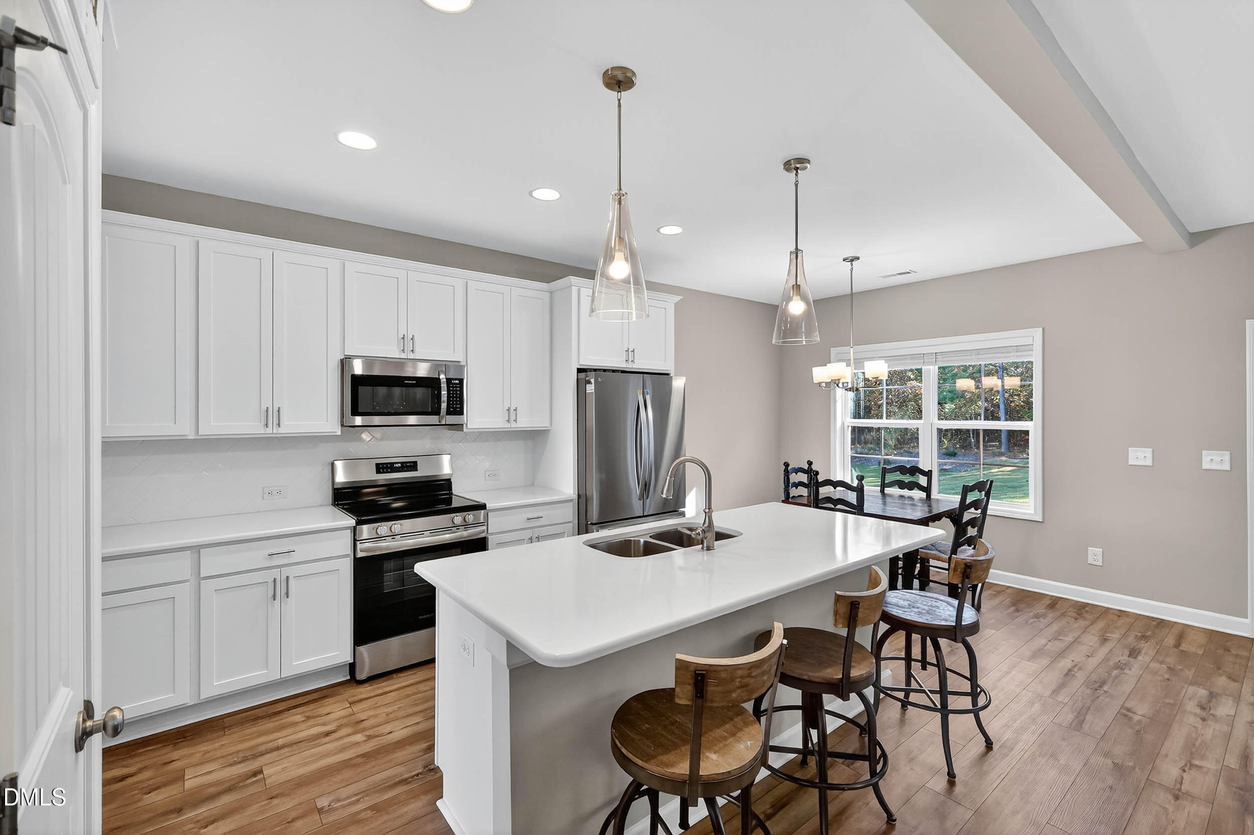 520 Husketh Road Youngsville, NC 27596 - Photo 13 of 63 a kitchen with stainless steel appliances kitchen island a table chairs in it and wooden floors