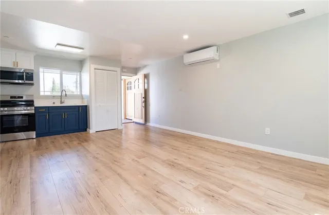 a view of a kitchen with wooden floor and stainless steel appliances