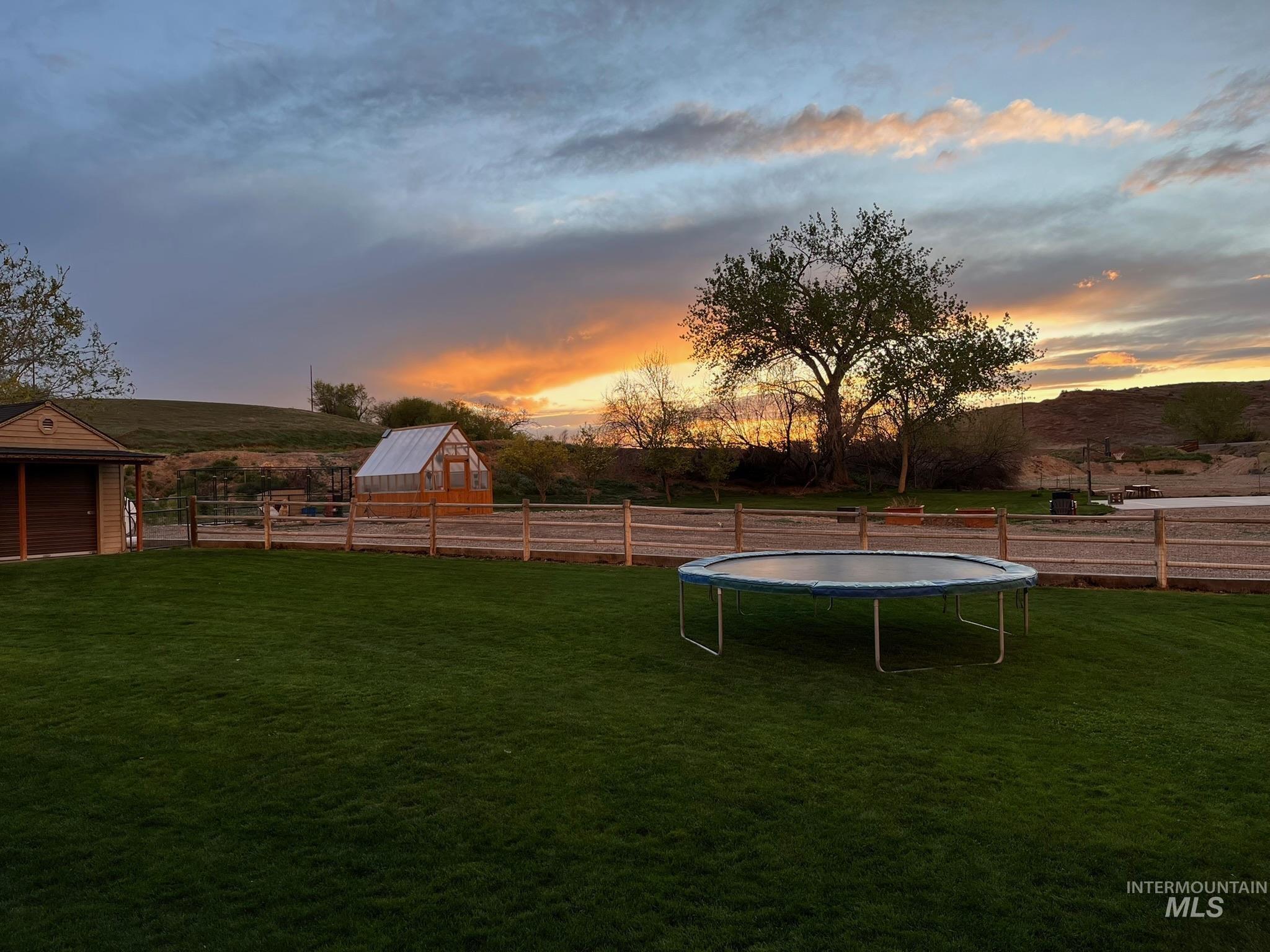 3091 Echo Road Nyssa, OR 97913 - Photo 13 of 36 Yard at dusk featuring a trampoline, an outdoor structure, and a rural view