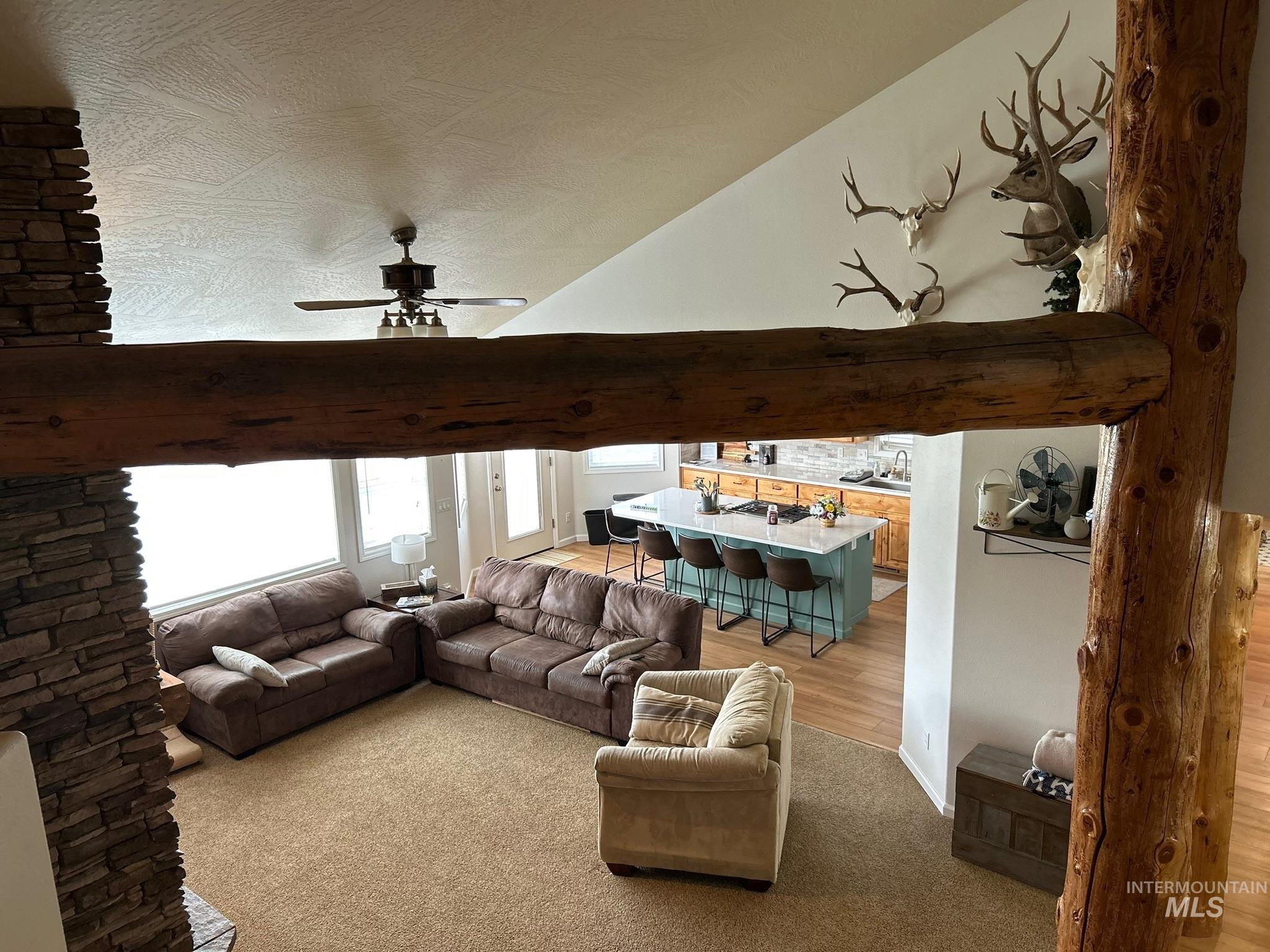 3091 Echo Road Nyssa, OR 97913 - Photo 4 of 36 Living room with light carpet, ceiling fan, vaulted ceiling, and light wood-type flooring