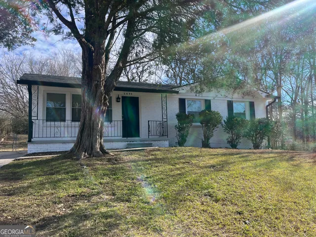 a view of a house with backyard and tree