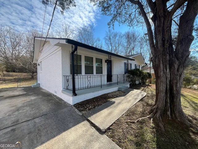 a view of backyard with a barn and a large tree