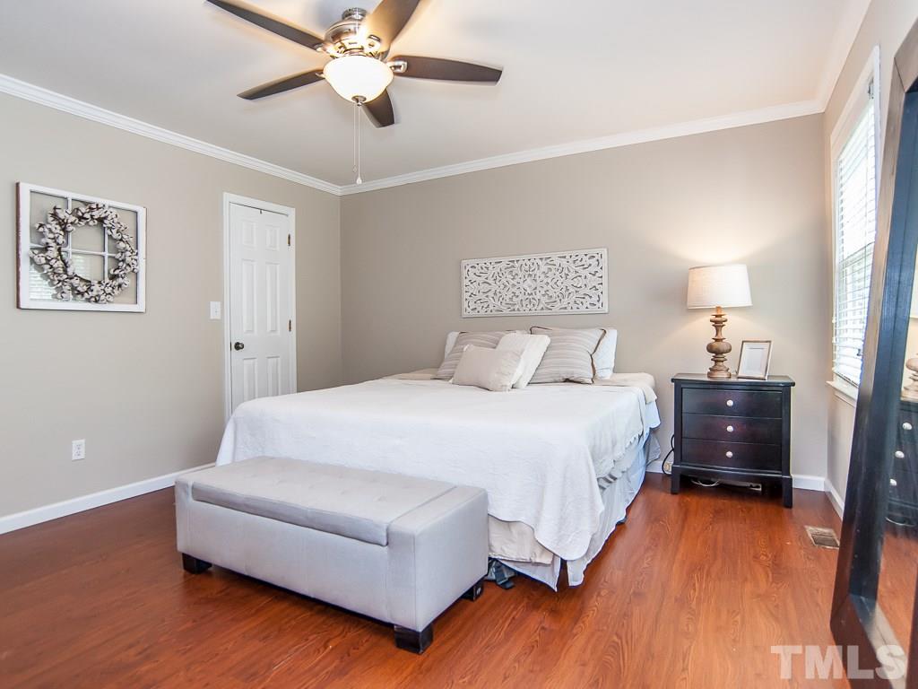 7605 Elliot Drive Raleigh, NC 27613 - Photo 9 of 22 a spacious bedroom with a bed and a chandelier