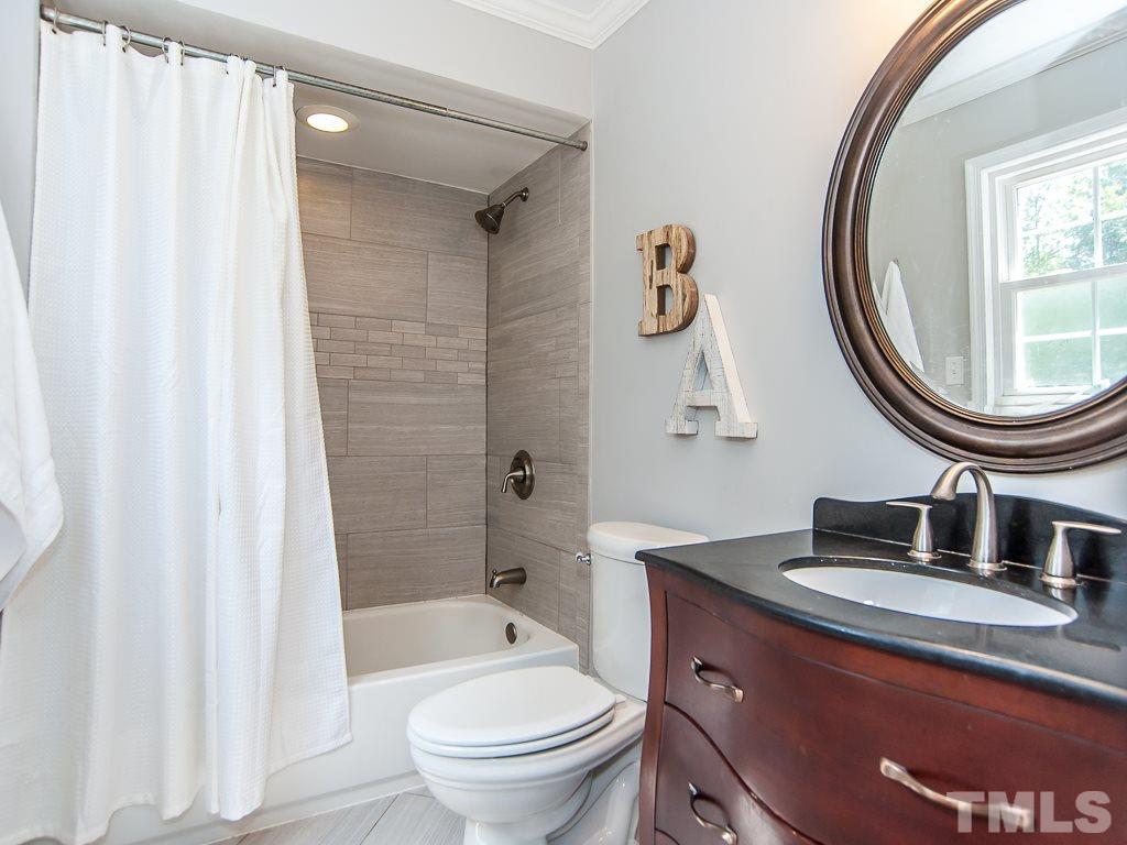 7605 Elliot Drive Raleigh, NC 27613 - Photo 10 of 22 a bathroom with a sink a toilet and a mirror