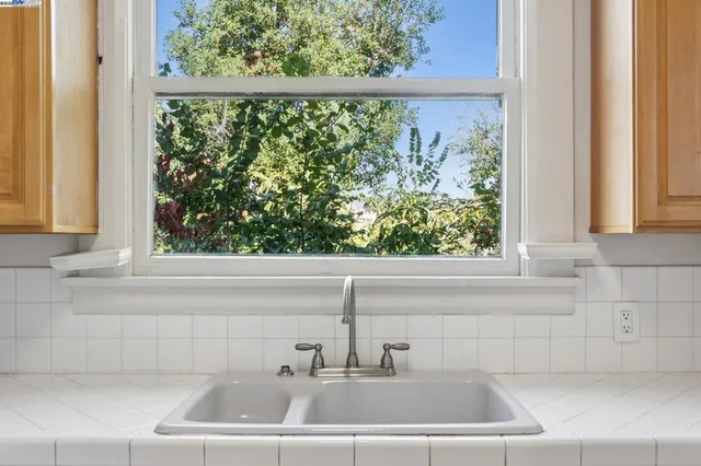 a view of an empty room with a window and a ceiling fan