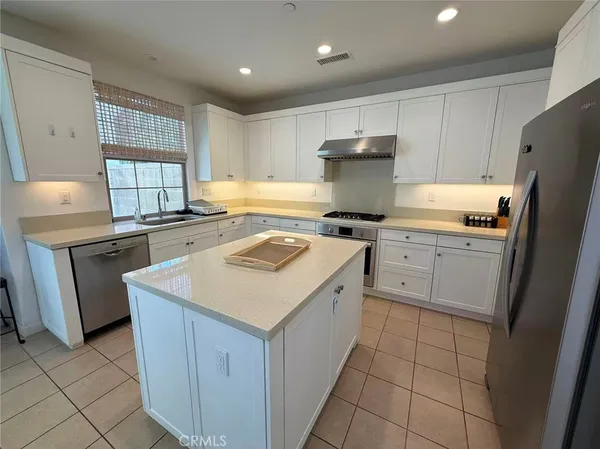 a kitchen with a stove a sink a refrigerator and cabinets