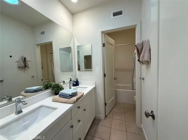 a bathroom with a double vanity sink mirror and shower