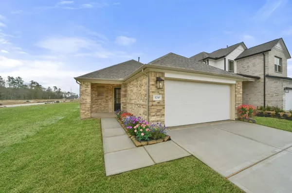 a front view of a house with a garden and yard
