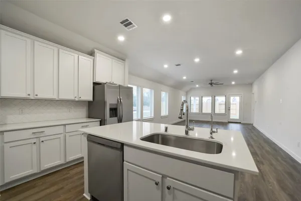 a kitchen with a sink window and cabinets