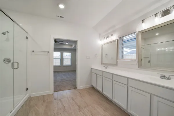 a bathroom with a double vanity sink and mirror with shower