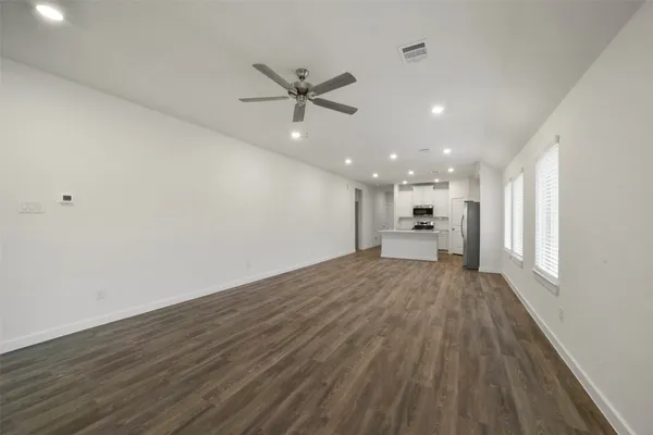 a view of empty room with wooden floor and window
