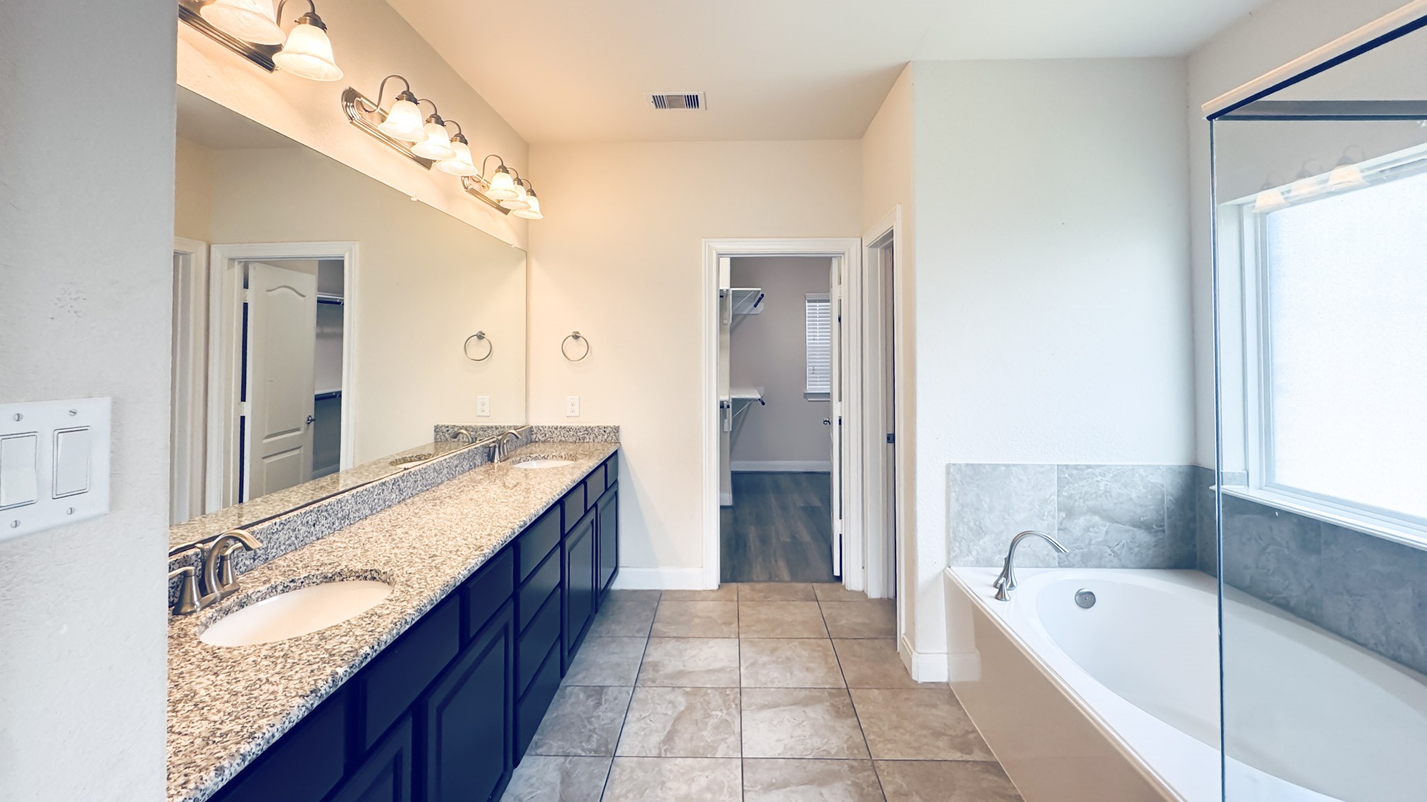 1236 Laurel Loop Angleton, TX 77515 - Photo 15 of 17 a spacious bathroom with a granite countertop tub sink and mirror