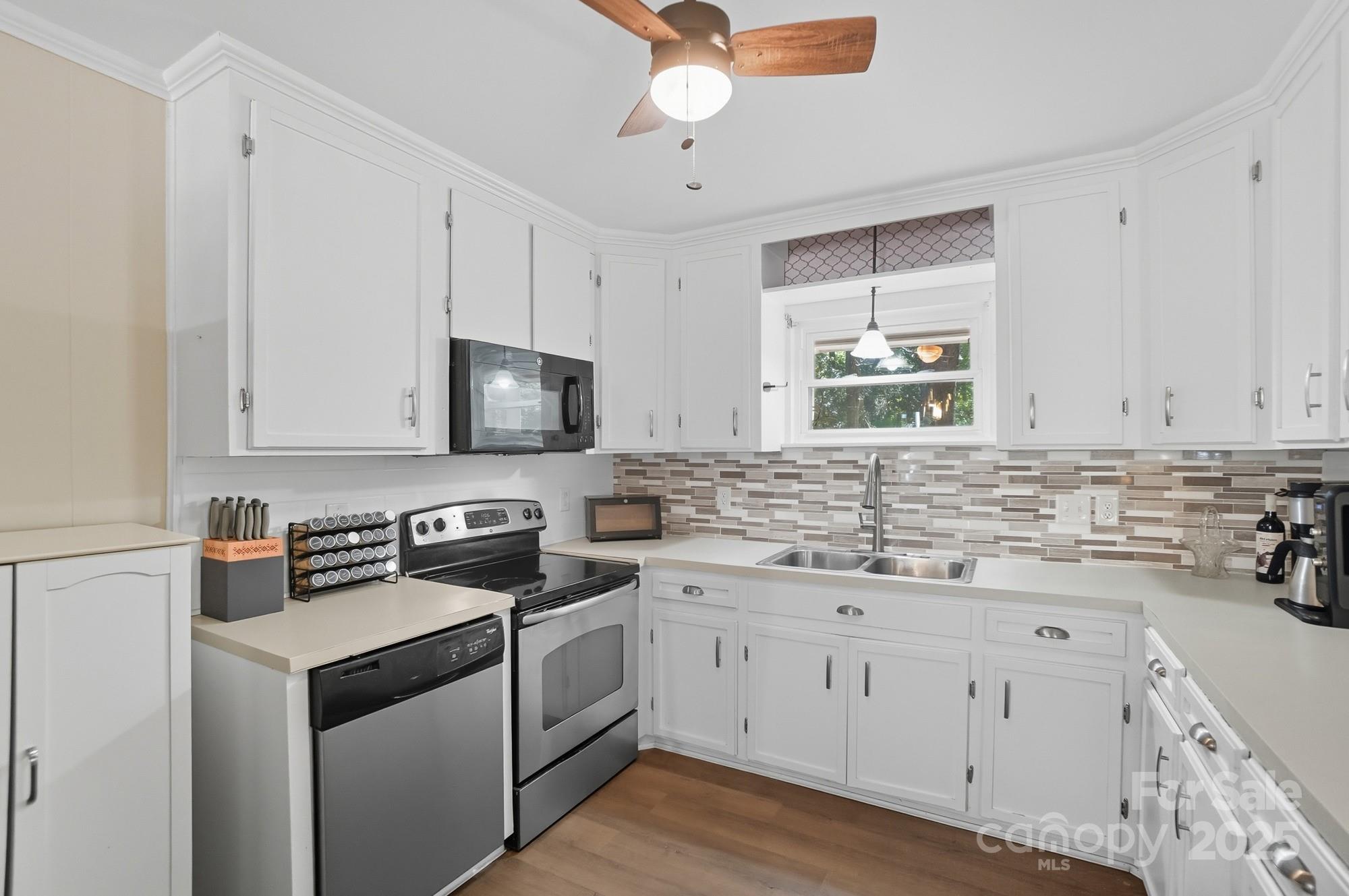 109 Carter Road Monroe, NC 28110 - Photo 18 of 48 a kitchen with cabinets appliances a sink and a window