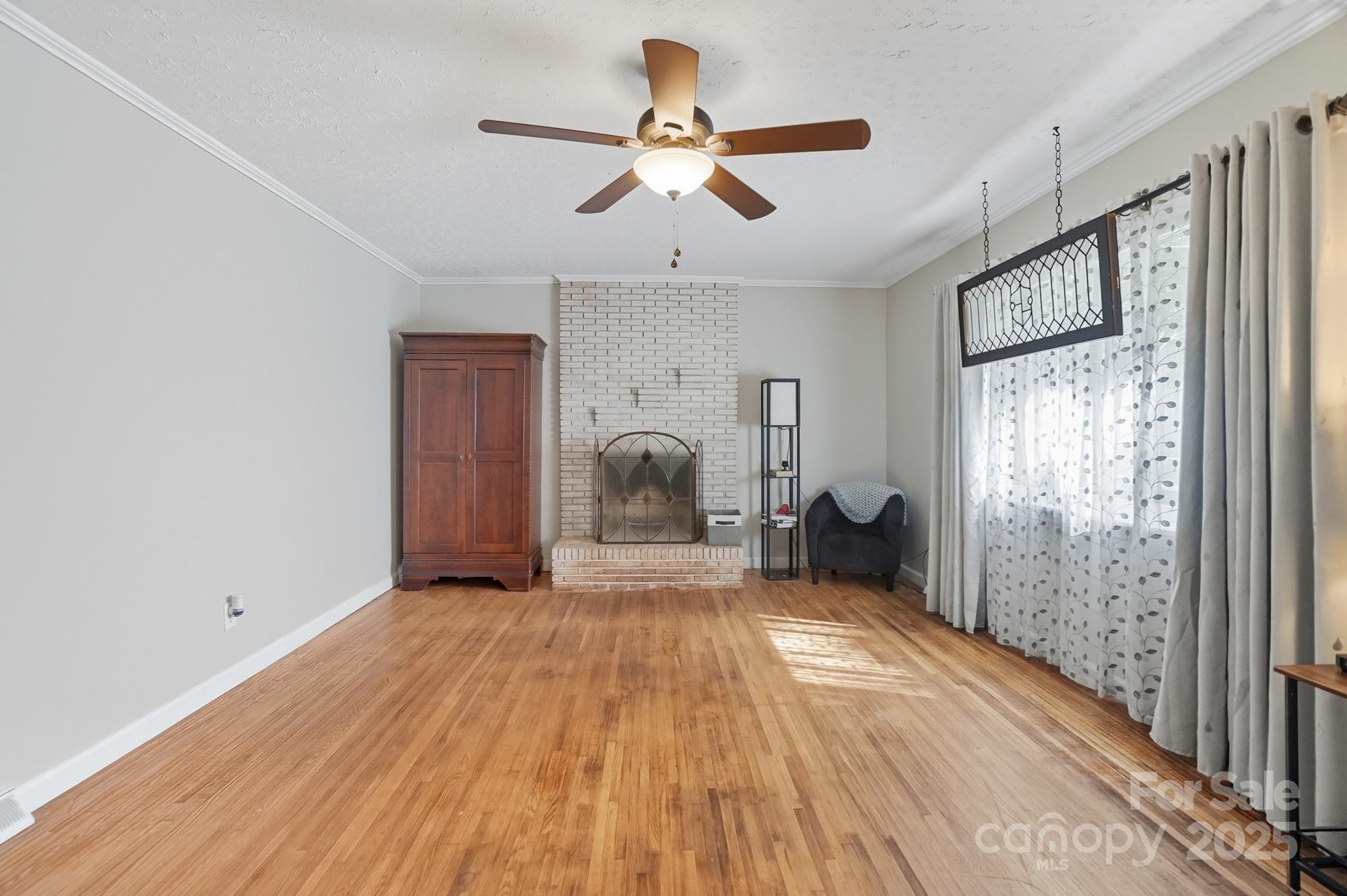 109 Carter Road Monroe, NC 28110 - Photo 27 of 48 a view of a big room with wooden floor a ceiling fan and windows